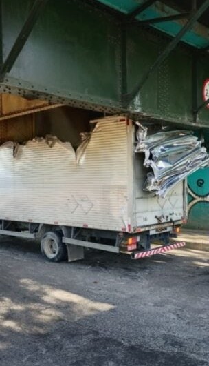 Caminhão fica preso em ponte e tem baú destruído em Volta Redonda